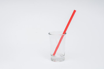 empty glass with red straws on a white background