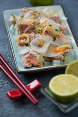 Slices of roasted yellowfin tuna fillet with noodles salad, studio shot, closeup