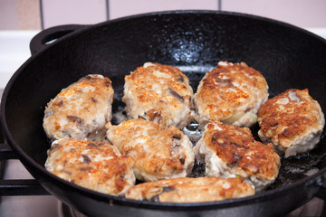 Delicious fried homemade fish cakes or cutlets on frying pan.