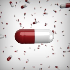 Massive red white gloss pills capsules on white background. One capsule in the foreground. 3D render