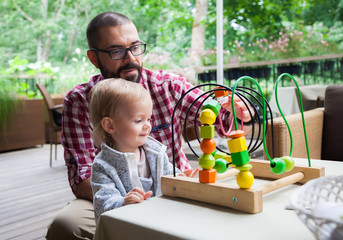 father showing his daughter how to play