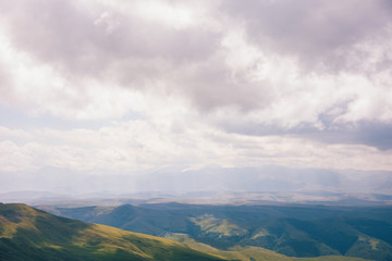 View from the Bermamyt Plateau on a summer day. Hills and clouds in the distance.