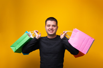 Photo of man with multi-colored shopping bags