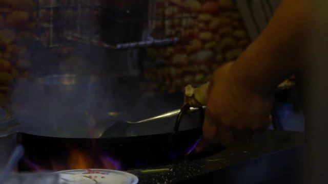 Slow Motion of man cooks vegetables on the fire at Taiwan restaurant kitchen. Chinese cheff cooking and stirring traditional food in wok. People eating delicious asiatic food.-Dan