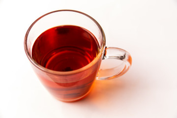 Glass cup filled with black tea isolated on a white background