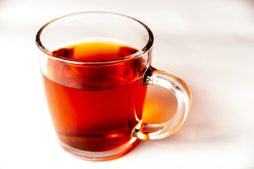 Glass cup filled with black tea isolated on a white background