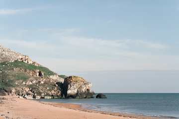 Fototapeta na wymiar rocky coast of the sea bordering a sandy beach