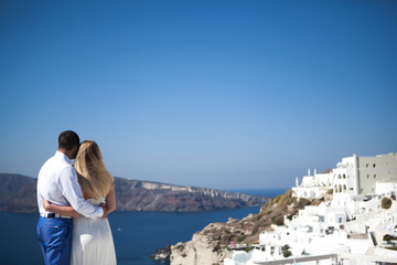 Fototapeta na wymiar young couple pregnant on the most romantic island Santorini, Greece