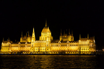 BUDAPEST, HUNGARY - MAR 07th, 2019: The Hungarian Parliament Building is the seat of the National Assembly of Hungary at the Danube river during night, one of Europe's oldest legislative buildings