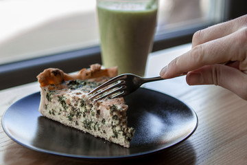 A photo of real food at a fast-service coffee shop. Pie with spinach and broccoli and a green smoothy strip