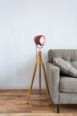 White loft interior with grey sofa and modern handmade lamp from old motorcycle headlight