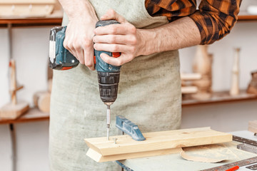 Worker man with screwdriver drill in carpentry. Handyman skills concept