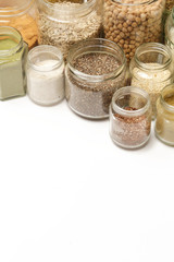Top view of jars with grains, seeds, legumes, flours and various food ingredients. Healthy food concept.