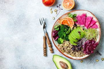Vegan, detox Buddha bowl with quinoa, micro greens, avocado, blood orange, broccoli, watermelon radish, alfalfa seed sprouts. Top view, flat lay, copy space