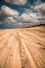 Fototapeta na wymiar Fahrspuren und Fahrrillen im Sand eines befahrbaren Strandes auf Fraser Island