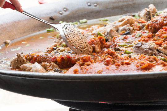 Paella tradicional con la esp&aacute;tula en el sofrito 