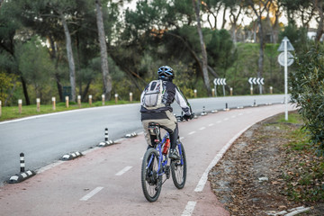Cyclist with backpack and helmet drives a mountain bike in a special lane for cyclists