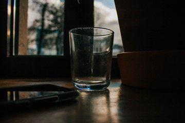 Cup of coffee on a wooden table with glass of water. Coffee shop in local area. Cozy retro style.