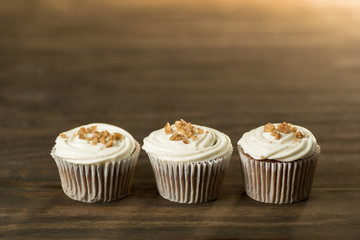 3 Cupcakes decorados con betún blanco y nuez