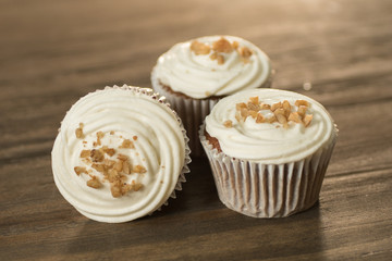 3 Cupcakes decorados con betún blanco y nuez