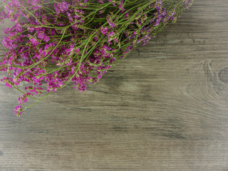 Flat lay,top view dried pink,purple flowers on grey wooden background with copy space 
