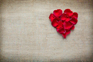 Red heart of roses petals isolated on a cloth background.
