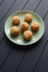 Diet and healthy dessert concept. Sugar free muffins in green plate on dark background minimalist style top view