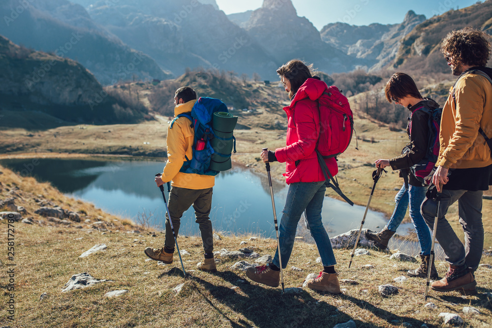 Wall mural group of hikers walking on a mountain at autumn day