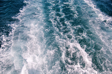 Turbulence made by foam of sea water from a high-speed yacht on surface of sea. Blue sea waves with...