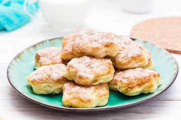 Ready-to-eat cottage cheese cookies on a plate on a wooden table.