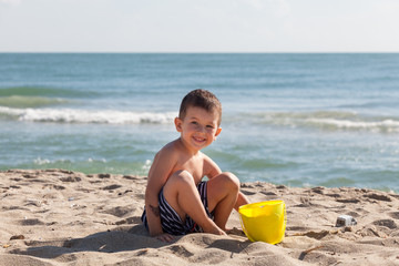 little boy play with sand on summer beach