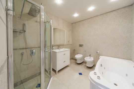 Clean bright stylish designer modern bathroom. Bathroom interior in luxury home with glass shower and bathtub