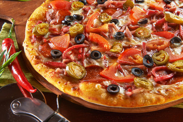Fresh pizza on wooden table with ingredients
