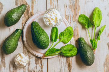Avocado, lime, spinach, ricotta cheese on a white worn background. top view
