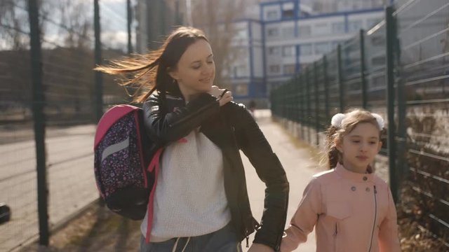 Mother and daughter go home from school after school.
