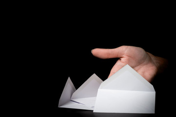 white envelope in a female hand on black background