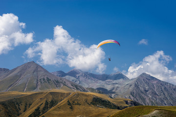 Paragliding in mountains. Extreme sport. Flight on paraglider over mountains of Caucasus.
