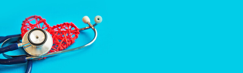 red heart with stethoscope isolated on blue background. banner for a clinic or insurance company