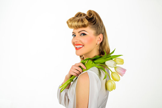 Beautiful girl in retro style with bouquet of tulips. Smiling woman with retro hairdo with tulips. Vintage style. Pin-up girl. Spring woman hold flower bouquet. Beauty, fashion concept. Happy birthday