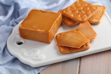 Crackers with Brunost, Norwegian Brown Cheese  on ceramic board