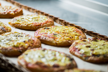 small pizzas and pastries in the basket on the bakery window