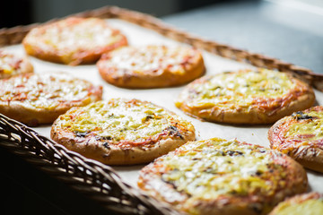small pizzas and pastries in the basket on the bakery window