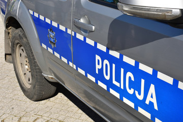 Obraz premium Door of the Polish Police car with telephone number 112 and symbol of Police, closeup