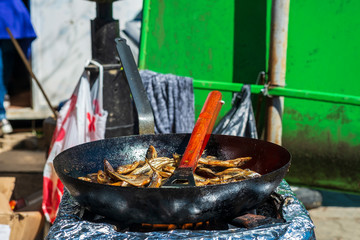 Fototapeta na wymiar Festival of wine and fish in the Montenegrin town Virpazar. Montenegrins fry and sell fish on the street for festival guests