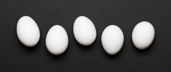 Fototapeta na wymiar White eggs on a black background. Banner. Healthy food. Top view, flat lay