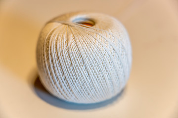 A ball of white thread on a beige background