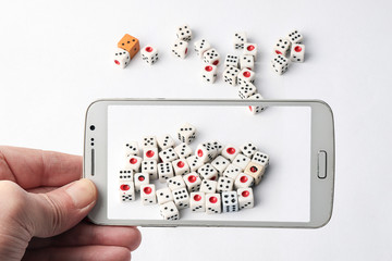 Mobile phone and dice chips on a white gaming table