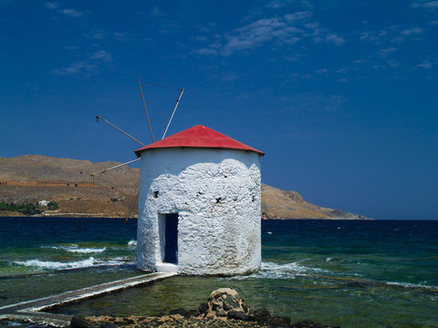 Traditional windmill in the sea. Landmark of Leros island, Greece.
