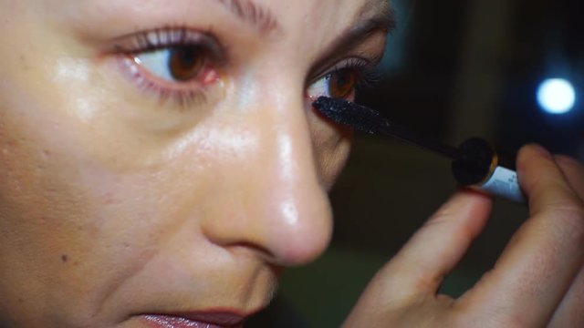 Girl paints eyelashes with mascara. 1920X1080 Full Hd.