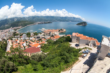 The city of Budva with the old town with fortified walls and red roofs. View from above, wide angle. Montenegro